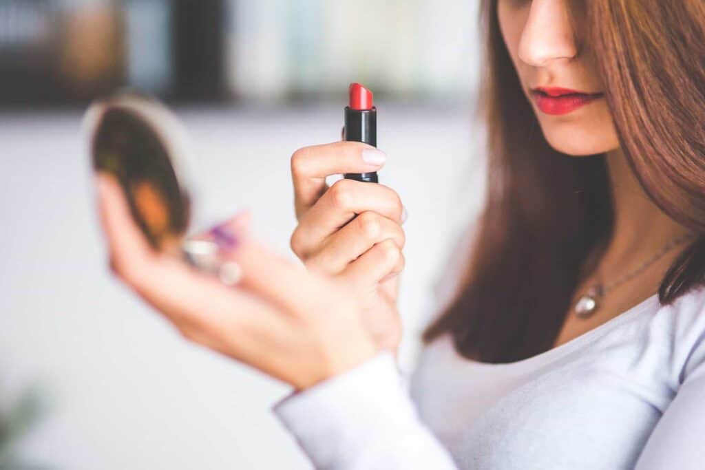 Heavy Metals are NOT pregnancy safe for lipstick: woman applying lipstick