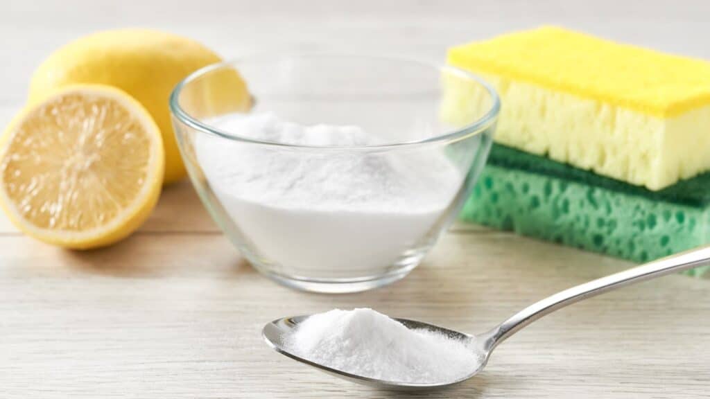 Best nontoxic bathroom cleanering products, including scrubs for toilet bowls. Picture of scrubbing brushes, baking soda, and lemons.